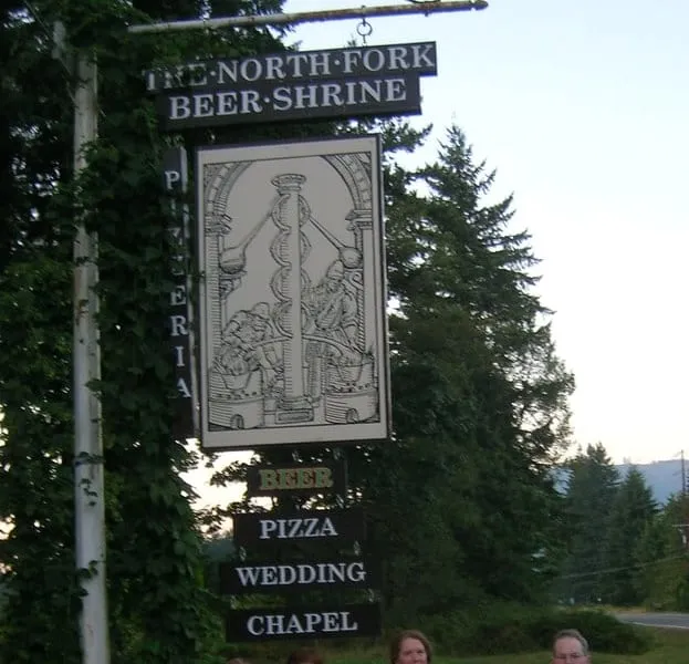 The North Fork Beer Shrine sign on the Mt. Baker Highway in Deming advertising beer, pizza and the wedding chapel