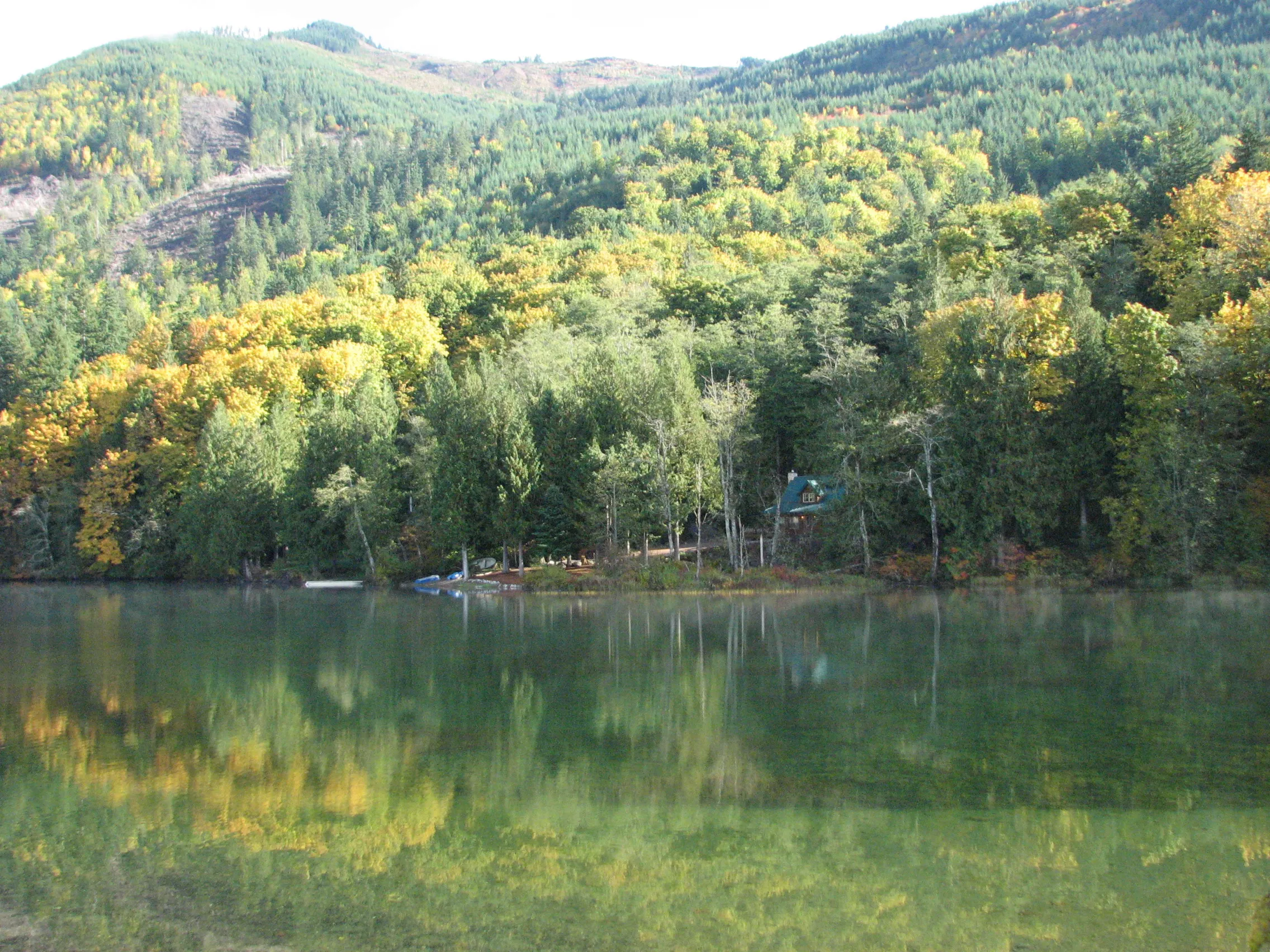 Autumn trees reflected in Silver Lake with a small building across the water