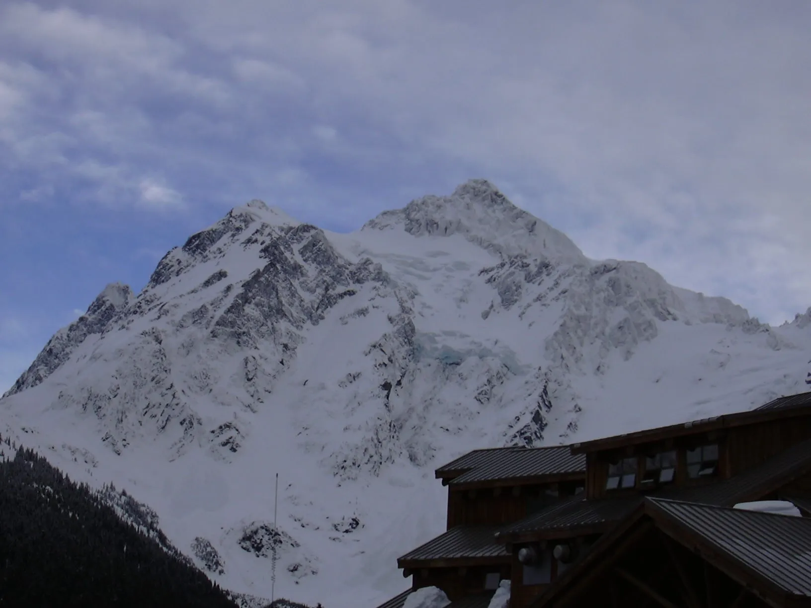 Mount Shuksan in winter above the roofline of the ski area day lodge at Mt. Baker